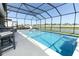 Gorgeous pool overlooking a lake, enhanced by a covered patio and stylish outdoor furniture at 13617 Haulover Beach Ln, Orlando, FL 32827