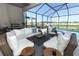 Expansive covered patio with an outdoor kitchen and inviting pool with serene lake views at 13617 Haulover Beach Ln, Orlando, FL 32827