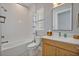 Cozy bathroom featuring a shower-tub combo, classic subway tile, and a wood vanity for a warm and inviting space at 14559 Walcott Ave, Orlando, FL 32827