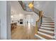 Grand foyer with staircase, contemporary chandelier, and views into kitchen with modern appliances at 14559 Walcott Ave, Orlando, FL 32827