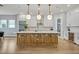 Stylish kitchen island with seating, quartz countertop, pendant lights, and white cabinetry at 14559 Walcott Ave, Orlando, FL 32827
