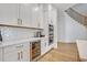 Modern kitchenette with built-in wine cooler, stainless oven, white cabinets, and tile backsplash at 14559 Walcott Ave, Orlando, FL 32827