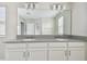 Bathroom featuring a double vanity with granite countertop and a large mirror with lighting at 15210 Chapter Way, Winter Garden, FL 34787