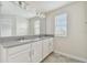 Bathroom featuring double vanity with granite countertop, chrome faucets, and a framed mirror with modern lighting at 15210 Chapter Way, Winter Garden, FL 34787