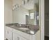 Bathroom featuring a double vanity with granite countertop, chrome faucets, and a framed mirror with lighting at 15210 Chapter Way, Winter Garden, FL 34787