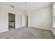 Bright carpeted bedroom with neutral walls and trim and an open doorway to the ensuite bathroom at 15210 Chapter Way, Winter Garden, FL 34787