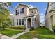 Charming two-story home featuring a stone archway entry and lush green lawn at 15210 Chapter Way, Winter Garden, FL 34787
