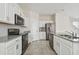 Modern kitchen with stainless steel appliances, gray countertops, and sleek white cabinets at 15210 Chapter Way, Winter Garden, FL 34787
