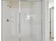 All white tiled shower with glass door and chrome shower fixtures and shelves at 15210 Chapter Way, Winter Garden, FL 34787