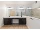 Bathroom with double vanity sinks, large mirrors, and glass-enclosed shower at 1539 Wynell St, St Cloud, FL 34771