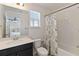 Bright bathroom featuring dark vanity with white sink, toilet and tub with decorative shower curtain at 1539 Wynell St, St Cloud, FL 34771