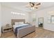 Brightly lit bedroom features a queen bed with blue blanket, two large windows, and a ceiling fan at 1539 Wynell St, St Cloud, FL 34771