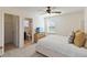 Bright bedroom includes ensuite bath, ceiling fan, dresser and plush bed with gold pillows at 1539 Wynell St, St Cloud, FL 34771