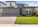 Charming two-story home with a stone facade, paver driveway and well-manicured lawn at 1539 Wynell St, St Cloud, FL 34771