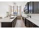 Spacious kitchen featuring dark cabinets, quartz countertops, and stainless steel appliances with an open floor plan at 1539 Wynell St, St Cloud, FL 34771