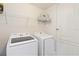 Functional laundry room features front load washer/dryer, white wire rack shelving and white door at 1539 Wynell St, St Cloud, FL 34771