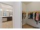 Hallway view to a walk-in closet and bathroom featuring wood-look floors and neutral paint at 1539 Wynell St, St Cloud, FL 34771
