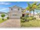Charming two-story home with manicured landscaping, brick driveway, and a two-car garage at 16078 St Clair St, Clermont, FL 34714