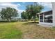 Expansive backyard featuring lush green grass, mature trees, and a screened-in patio, perfect for outdoor enjoyment at 1986 Yellowfin Dr, Port Orange, FL 32128