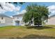 Spacious backyard features mature tree, screened in lanai, and comfortable seating area with bright blue chairs at 1986 Yellowfin Dr, Port Orange, FL 32128