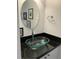 Stylish bathroom features a vessel sink, black countertop and oval mirror at 1986 Yellowfin Dr, Port Orange, FL 32128