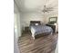 This bedroom features wood floors, a ceiling fan, a sliding door to a pool, and coordinating lamps and bedroom furniture at 2236 Dancy Trail Trl, Clermont, FL 34714