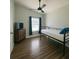 Cozy bedroom with modern ceiling fan, wood floors and natural light through a window at 2236 Dancy Trail Trl, Clermont, FL 34714