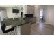 Modern kitchen features gray cabinets, granite countertops, stainless steel appliances, and a breakfast bar at 2236 Dancy Trail Trl, Clermont, FL 34714