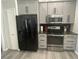 Modern kitchen featuring stainless-steel appliances, gray cabinets, and a black refrigerator at 2236 Dancy Trail Trl, Clermont, FL 34714
