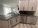 Well-designed kitchen with granite countertops, gray cabinets, stainless steel appliances and bar stool seating at 2236 Dancy Trail Trl, Clermont, FL 34714