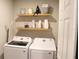 Convenient laundry room with shelving, washer, and dryer for easy chore management at 2415 Sweet Viburnum Way, Ocoee, FL 34761