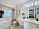 Bright bathroom with a shower-tub combo, vanity, and view into the main bedroom at 2744 Calabria Ave, Davenport, FL 33897