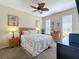 Bright bedroom features a ceiling fan, cozy décor, and natural light from two windows at 2744 Calabria Ave, Davenport, FL 33897