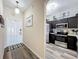 Inviting entryway featuring wood-look floors, leading into a kitchen with stainless steel appliances at 2744 Calabria Ave, Davenport, FL 33897