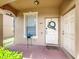 Cozy front porch with decorative wreath, side door, potted plant, and neutral tones at 2744 Calabria Ave, Davenport, FL 33897