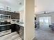 Open-concept kitchen featuring dark cabinets, stainless steel appliances and view to the living room at 2744 Calabria Ave, Davenport, FL 33897