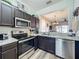 Well-equipped kitchen featuring modern stainless steel appliances and sleek dark cabinetry at 2744 Calabria Ave, Davenport, FL 33897
