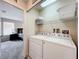 Functional laundry room setup with washer, dryer, shelving, and utility sink at 2744 Calabria Ave, Davenport, FL 33897