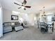 Open living space with carpet, ceiling fan and view of the staircase and dining area at 2744 Calabria Ave, Davenport, FL 33897