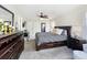 Spacious bedroom with a ceiling fan, dark wood furniture, and access to the bathroom and walk-in closet at 2744 Calabria Ave, Davenport, FL 33897