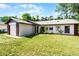 Landscaped single-story house with a brick trimmed garage and expansive front lawn at 288 Howard Blvd, Longwood, FL 32750
