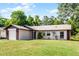 Well-kept single-story home featuring a lush front lawn and mature trees in a serene neighborhood at 288 Howard Blvd, Longwood, FL 32750