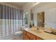 Bathroom features wooden cabinets, a large mirror, and shower with striped curtain at 316 Solaris Wharf St, Winter Springs, FL 32708