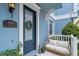 Charming blue home's front door with a decorative wreath, seating, and landscaping at 316 Solaris Wharf St, Winter Springs, FL 32708