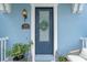Close up of the charming blue townhouse front door with wreath and manicured landscaping at 316 Solaris Wharf St, Winter Springs, FL 32708