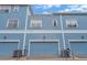 Exterior view of a row of two-story blue townhouses with blue garage doors and white trim at 316 Solaris Wharf St, Winter Springs, FL 32708