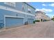 This is an exterior shot of a row of blue townhouses with brick paving at 316 Solaris Wharf St, Winter Springs, FL 32708