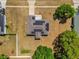 Aerial view of home with solar panels on roof surrounded by lawns, trees, and neighborhood fences under blue sky at 326 Woodland Trl, Lady Lake, FL 32159