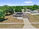 Aerial view of a home with solar panels on the roof and a long driveway leading to an attached garage at 326 Woodland Trl, Lady Lake, FL 32159