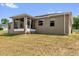Tan home with a screened in porch and a yard with dry grass visible under a partly cloudy blue sky at 326 Woodland Trl, Lady Lake, FL 32159
